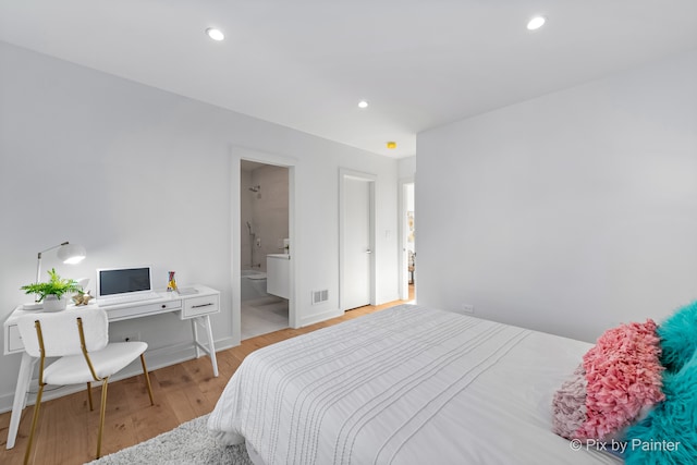 bedroom with light hardwood / wood-style floors and connected bathroom