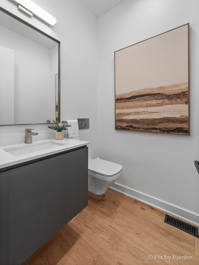 bathroom featuring vanity, toilet, and wood-type flooring