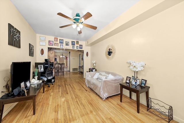 living room featuring light hardwood / wood-style flooring and ceiling fan