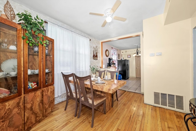 dining space with light hardwood / wood-style floors and ceiling fan