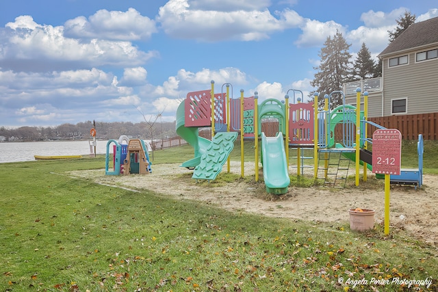 view of jungle gym with a water view and a lawn