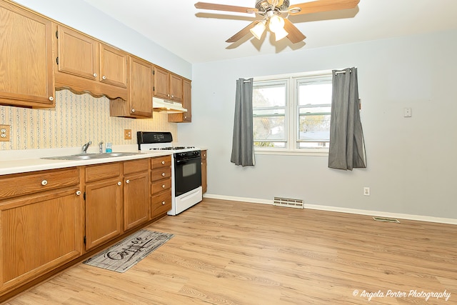 kitchen with ceiling fan, light hardwood / wood-style floors, sink, and white gas range oven