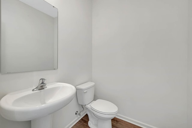 bathroom with sink, wood-type flooring, and toilet