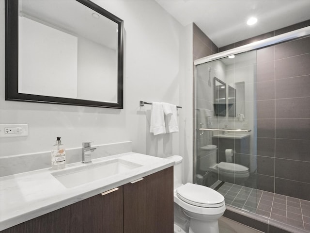 bathroom with an enclosed shower, vanity, and toilet