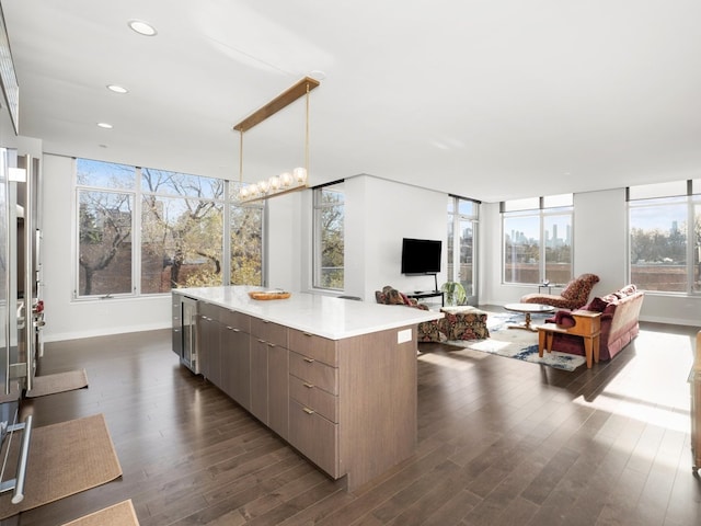 kitchen with pendant lighting, a center island, dark hardwood / wood-style floors, and an inviting chandelier