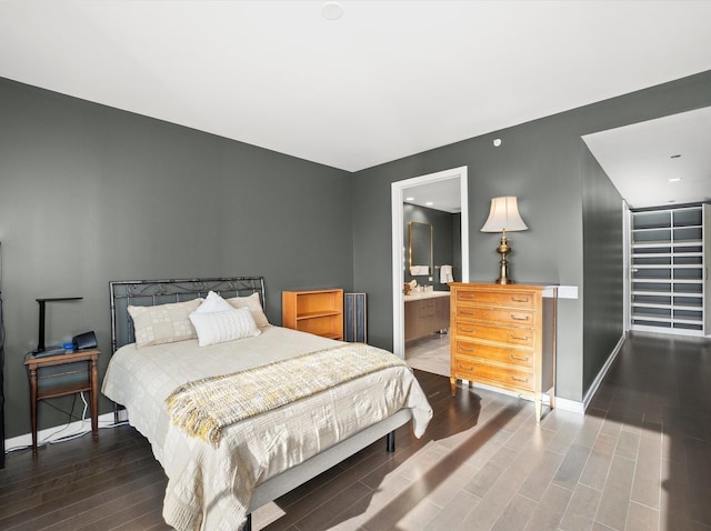 bedroom with dark hardwood / wood-style floors and connected bathroom