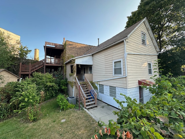 back of property featuring a lawn and central AC unit