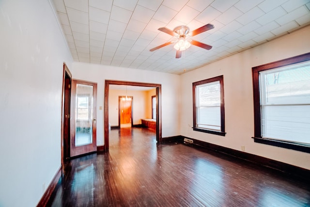 spare room with ceiling fan, a healthy amount of sunlight, and dark hardwood / wood-style floors