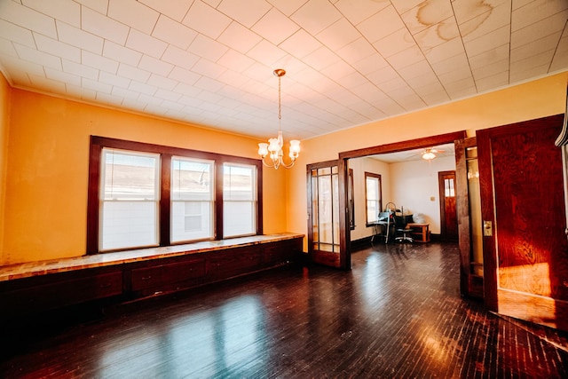 unfurnished room with ornamental molding, dark wood-type flooring, and a notable chandelier