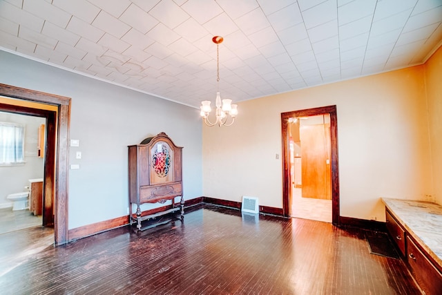 dining space with crown molding, dark hardwood / wood-style floors, and a chandelier