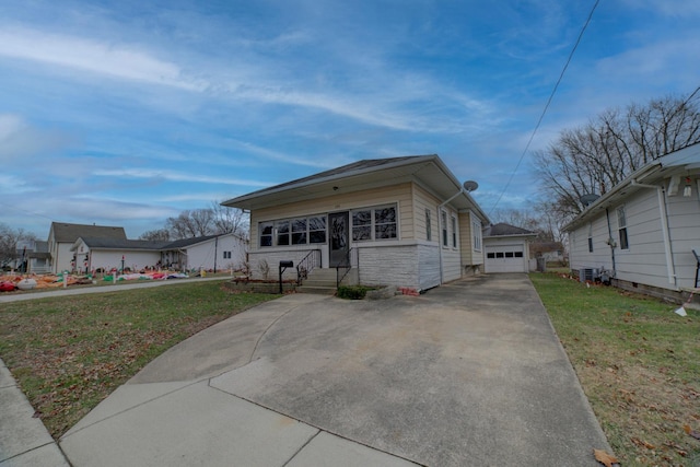 bungalow with an outbuilding, a garage, and a front yard