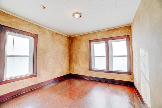 spare room featuring ornamental molding, plenty of natural light, and hardwood / wood-style floors