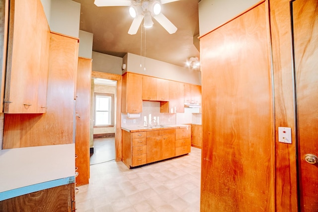 kitchen featuring ceiling fan, light brown cabinetry, sink, and backsplash