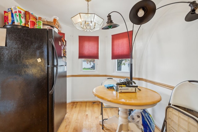 dining area with a notable chandelier and light hardwood / wood-style flooring