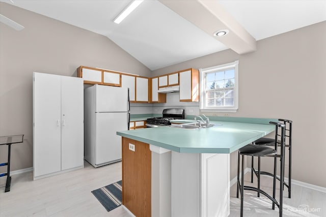 kitchen featuring black range with gas cooktop, sink, light wood-type flooring, and white refrigerator