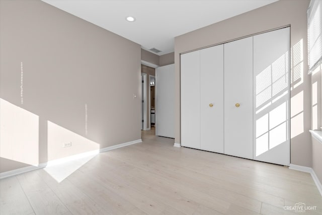 unfurnished bedroom featuring light hardwood / wood-style floors and a closet