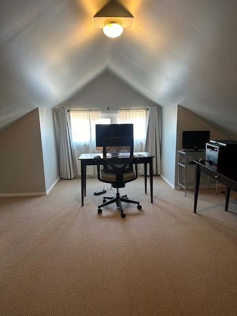 carpeted office space featuring vaulted ceiling and a wealth of natural light