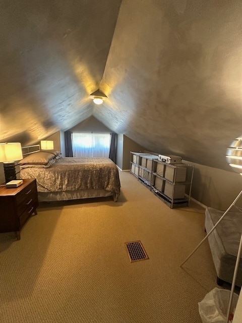 unfurnished bedroom with vaulted ceiling and carpet floors