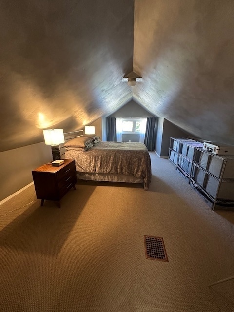 unfurnished bedroom featuring carpet flooring and vaulted ceiling