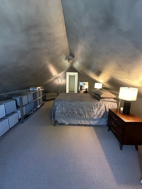 carpeted bedroom with lofted ceiling