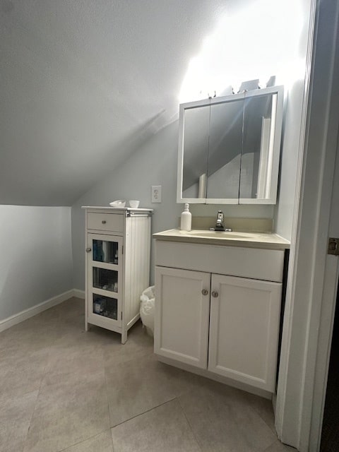 bathroom featuring vanity, lofted ceiling, and a textured ceiling