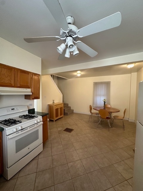 kitchen featuring light tile patterned floors, white appliances, and ceiling fan