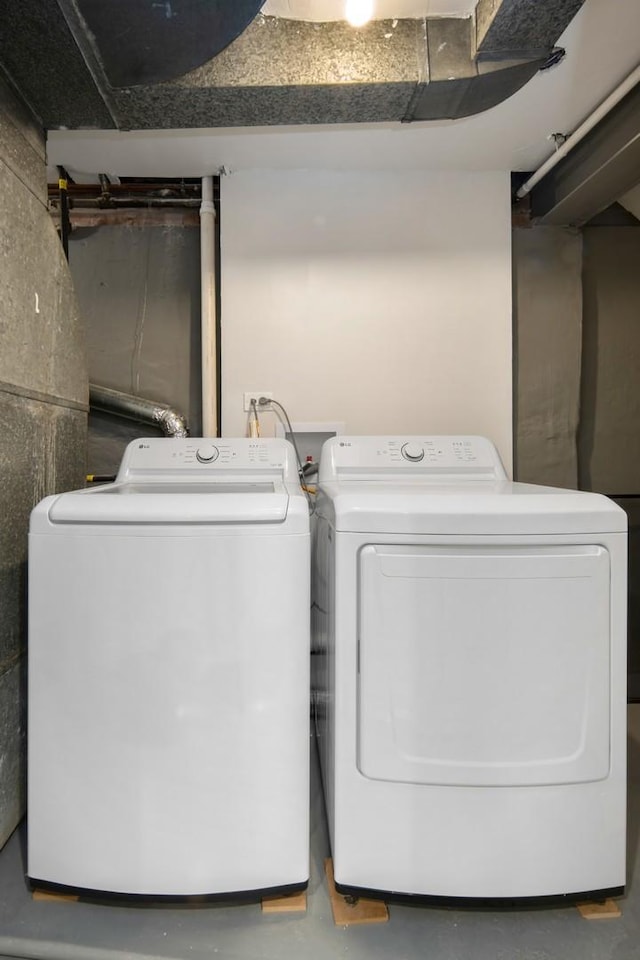 clothes washing area with washer and clothes dryer