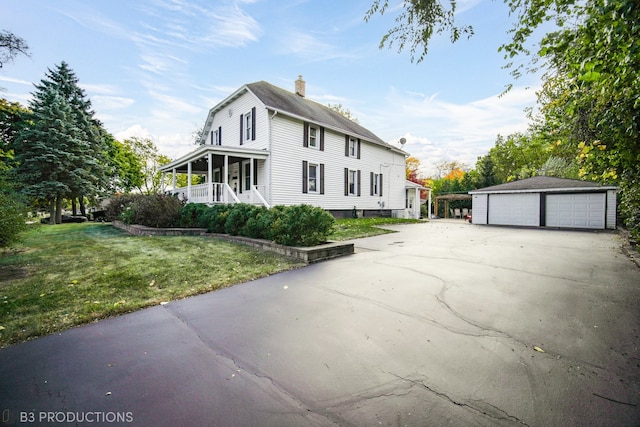 view of side of home featuring a yard, an outbuilding, and a garage