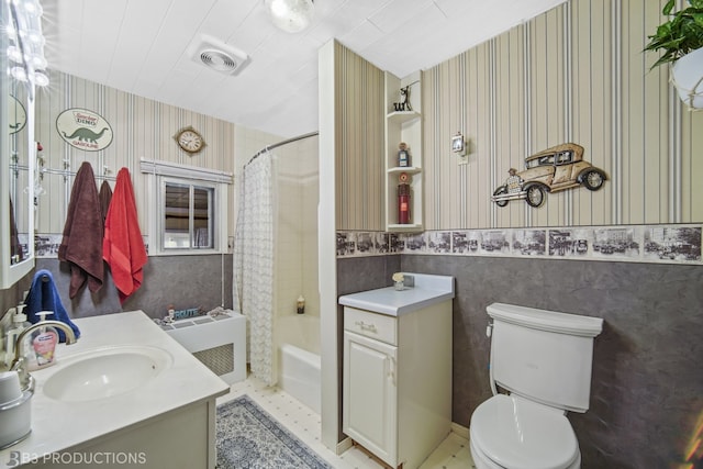 full bathroom with tile patterned floors, toilet, shower / bath combination with curtain, vanity, and tile walls