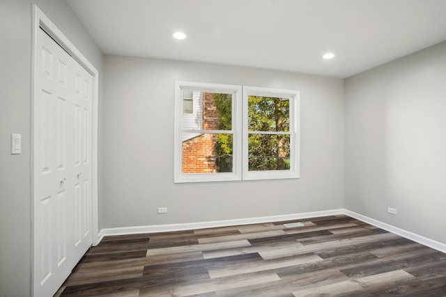 unfurnished bedroom featuring a closet and dark hardwood / wood-style flooring