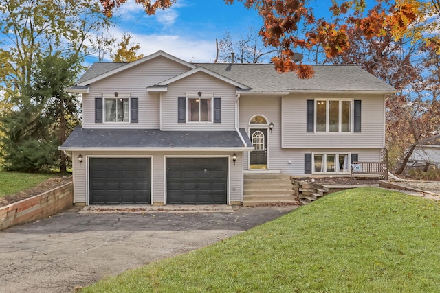 raised ranch featuring a front lawn and a garage