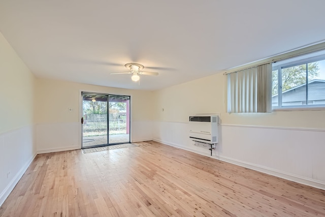 spare room featuring light hardwood / wood-style floors, ceiling fan, and heating unit