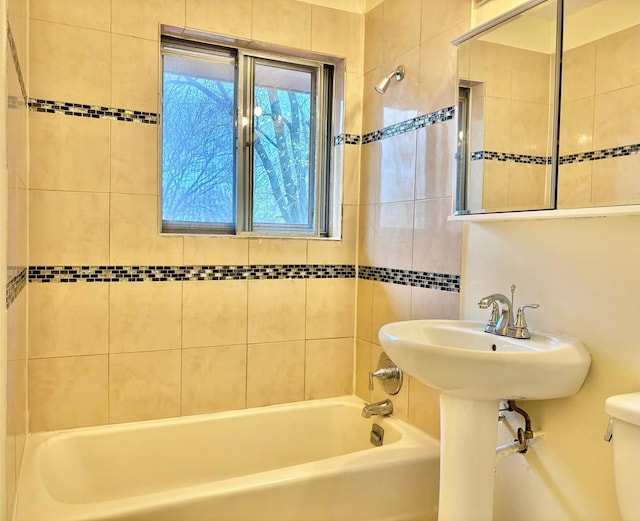 bathroom featuring toilet and tiled shower / bath combo