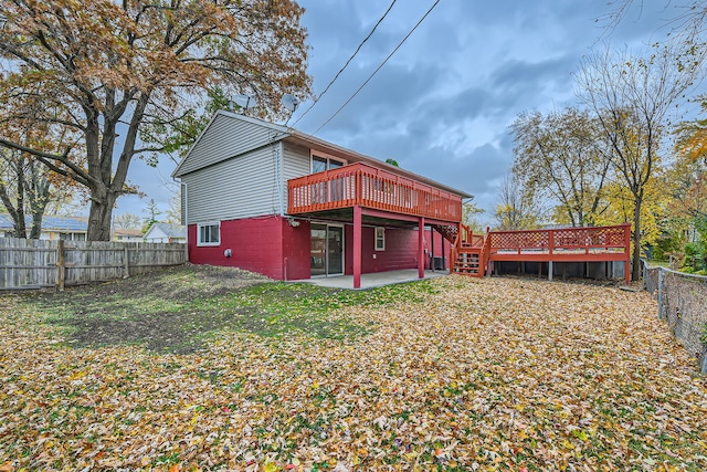 back of property featuring a deck, a lawn, and a patio area