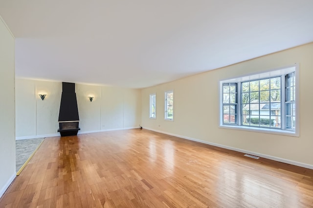 unfurnished living room featuring a wealth of natural light and light hardwood / wood-style flooring