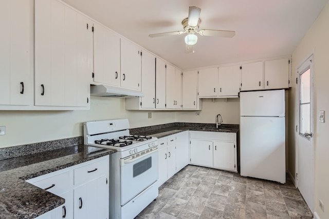 kitchen with white appliances, dark stone countertops, white cabinetry, and sink