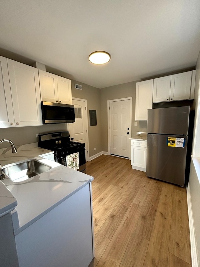 kitchen featuring sink, appliances with stainless steel finishes, and white cabinetry