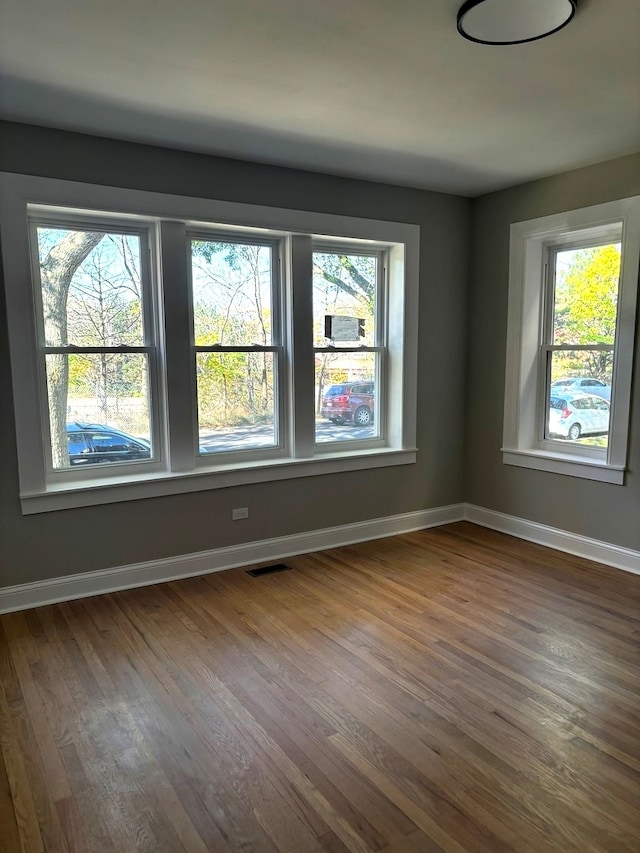 unfurnished room with hardwood / wood-style floors