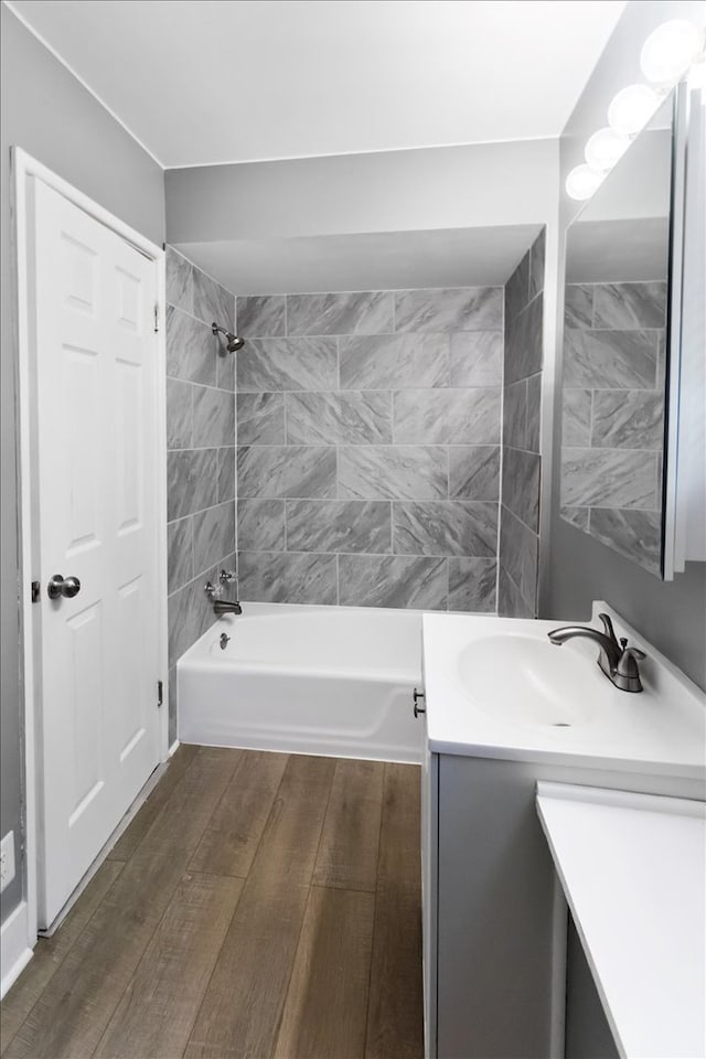 bathroom featuring vanity, hardwood / wood-style floors, and tiled shower / bath