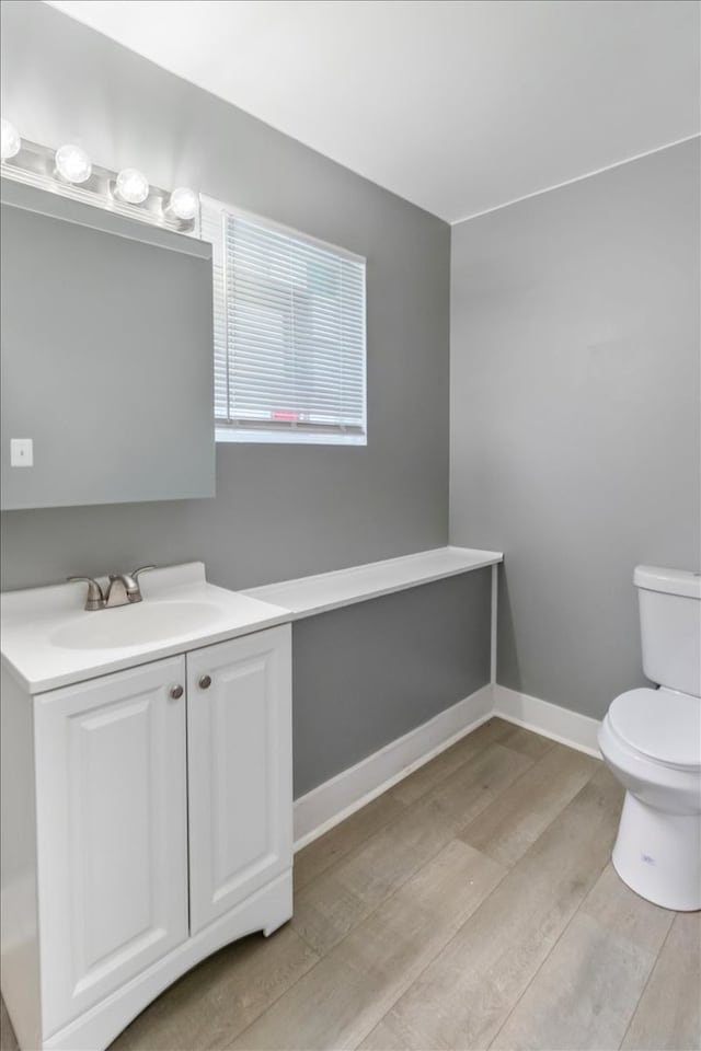 bathroom with vanity, hardwood / wood-style floors, and toilet