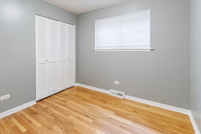 unfurnished bedroom featuring a closet and hardwood / wood-style flooring