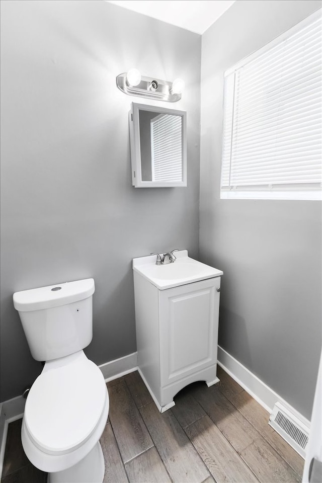 bathroom with vanity, hardwood / wood-style flooring, and toilet