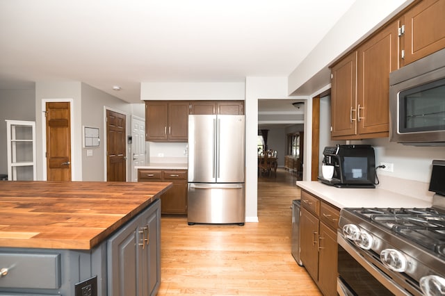 kitchen featuring butcher block counters, light hardwood / wood-style flooring, and stainless steel appliances