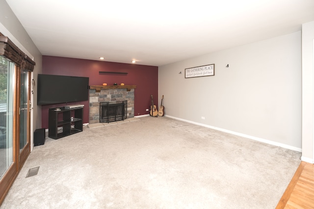 living room with a stone fireplace and hardwood / wood-style flooring