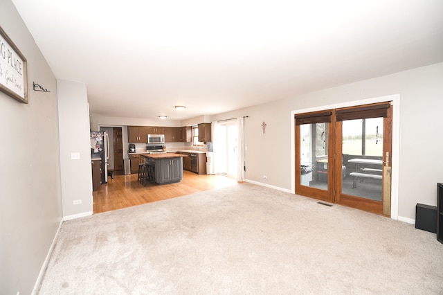 unfurnished living room with light colored carpet