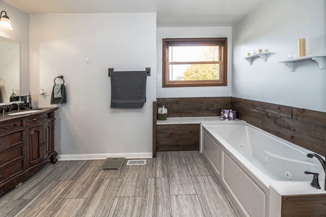 bathroom with vanity, a bathtub, and wood-type flooring