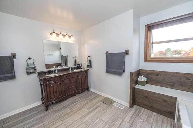 bathroom featuring vanity and a tub