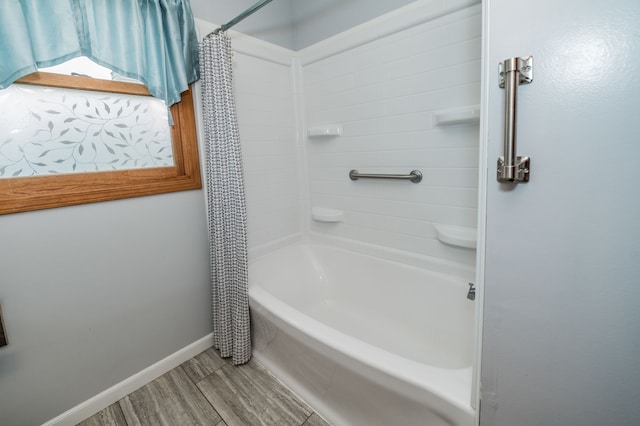 bathroom featuring wood-type flooring and shower / tub combo