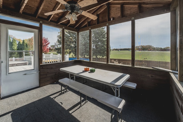 sunroom with ceiling fan and lofted ceiling with beams