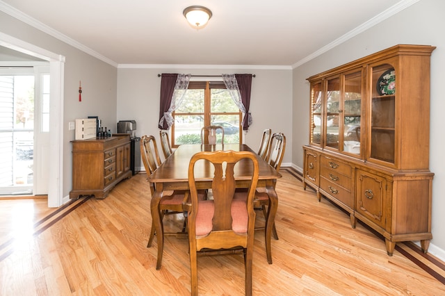 dining space with light hardwood / wood-style flooring, ornamental molding, and a wealth of natural light